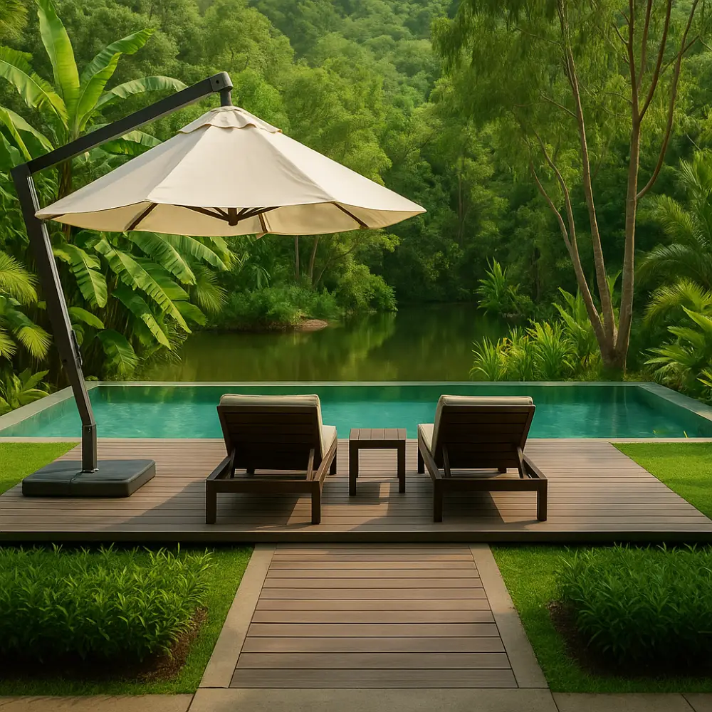 Serene backyard pool deck with two lounge chairs under a large umbrella, overlooking a tropical infinity pool and lush greenery.